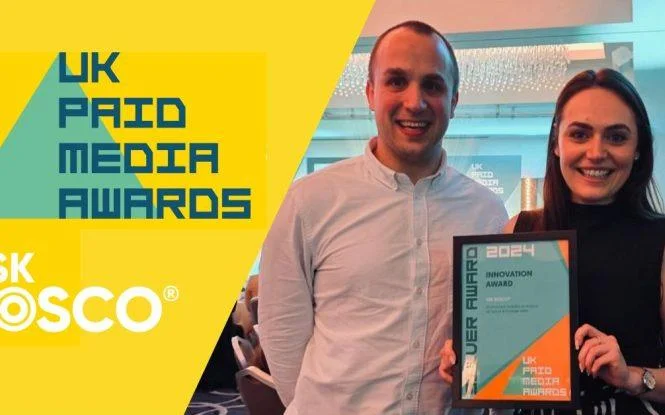 Two people holding ASK BOSCO's Innovation Award at the 2024 UK Paid Media Awards ceremony