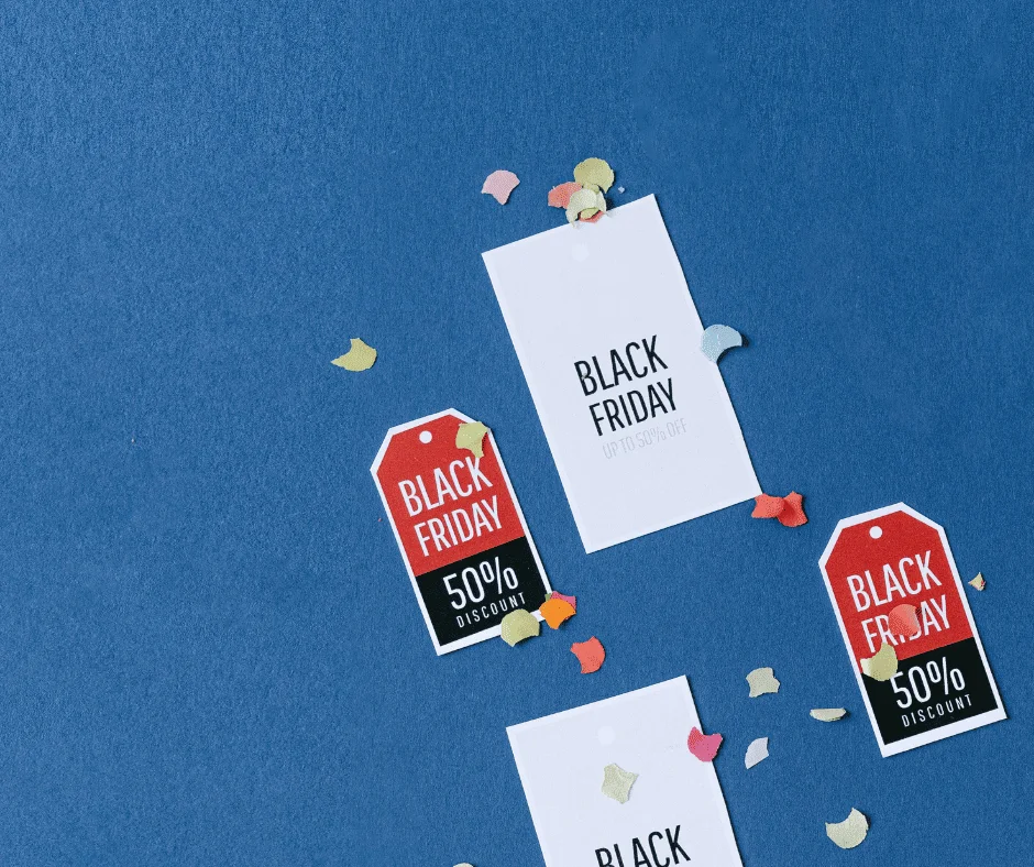 Black Friday 2023 Trends sale tags with 50% discount labels scattered on blue background with confetti