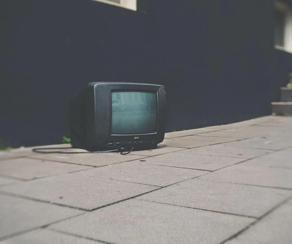 An old discarded television abandoned on a sidewalk, symbolizing shifting ad spend away from traditional TV media.