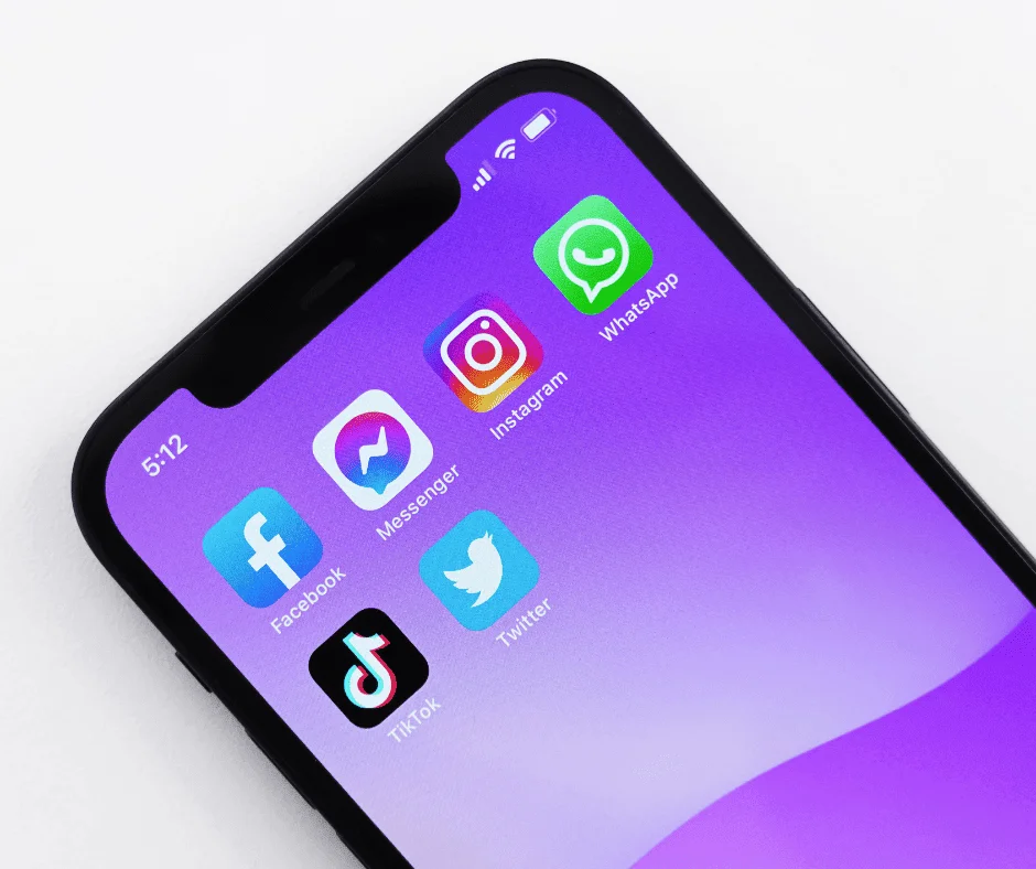 Smartphone screen displaying social media app icons, illustrating platforms used for paid social and organic social strategies.