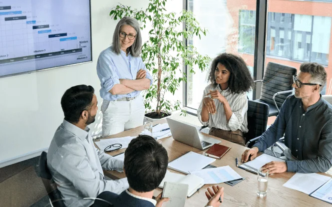 Team reviews project timelines and data to forecast in paid search during a business meeting.