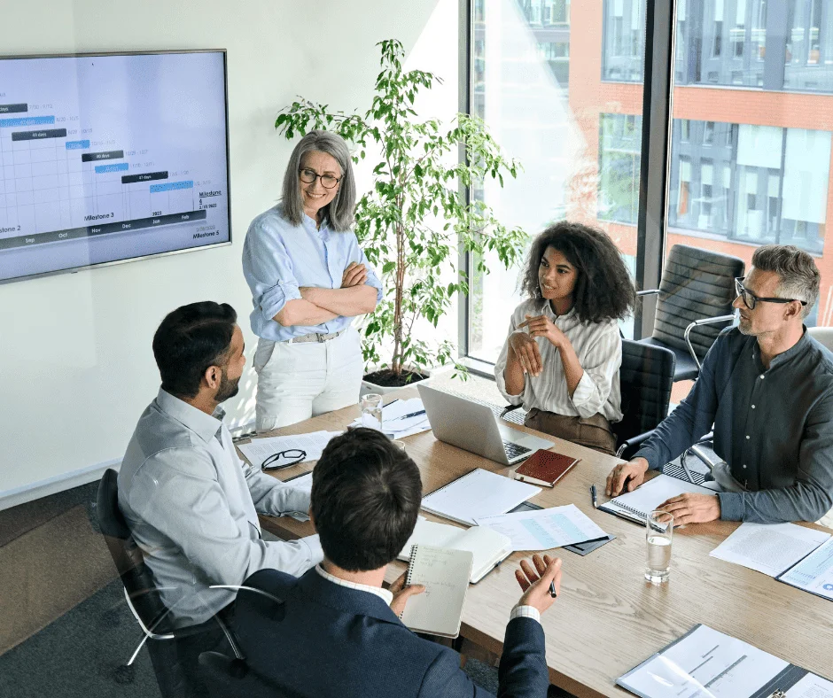 Team reviews project timelines and data to forecast in paid search during a business meeting.