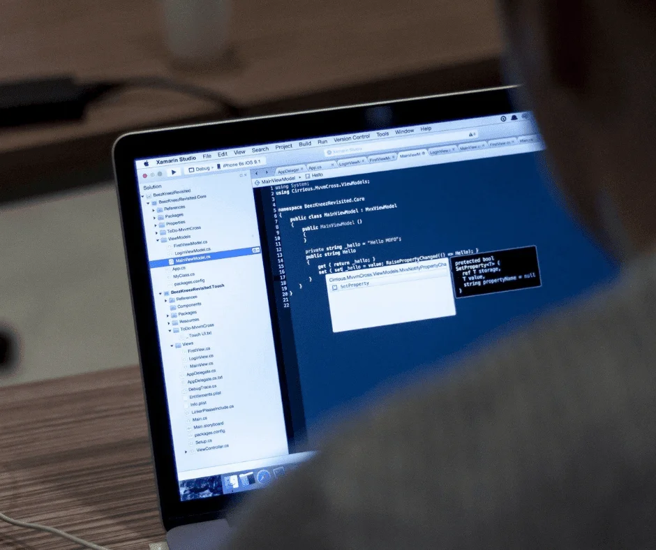 Laptop screen showing Xamarin Studio code editor, unrelated to auto-tagging setup in Google Ads.