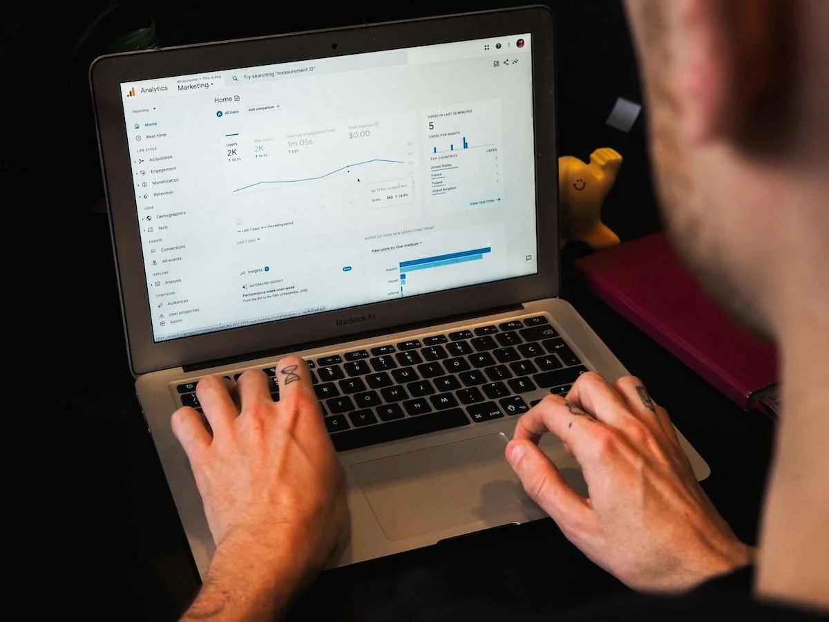 Person analyzing a GA4 analytics dashboard on a laptop, exploring GA4 pros and cons for marketing insights. Person analyzing a GA4 analytics dashboard on a laptop, exploring GA4 pros and cons for marketing insights.