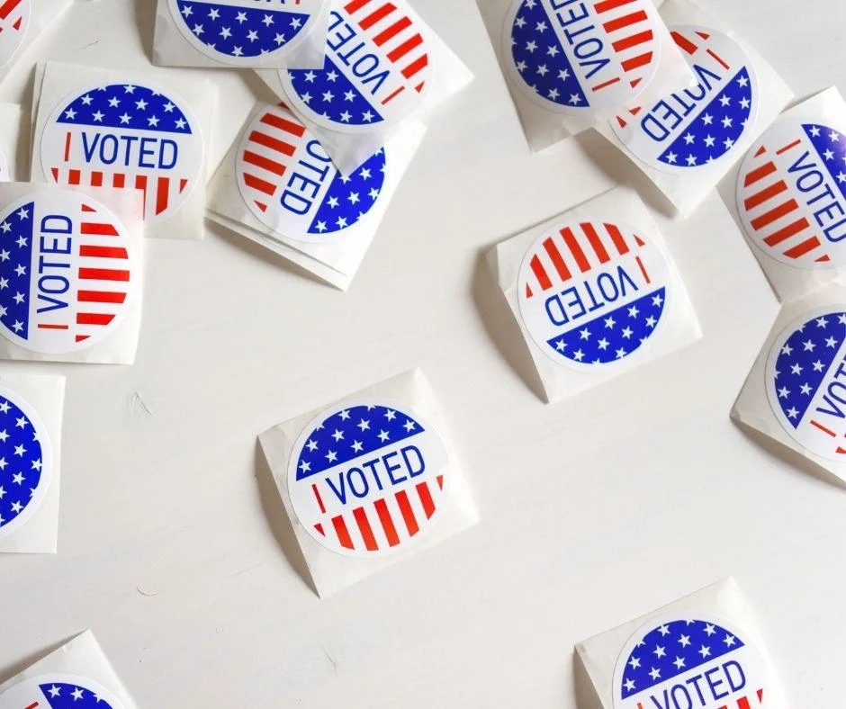 Scattered "I Voted" stickers with American flag design, symbolizing participation in the US election.
