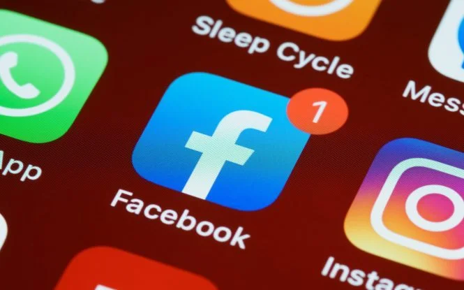 Smartphone home screen showing the Facebook app icon with a notification badge, relevant to iOS 14 privacy changes affecting Facebook ad tracking.