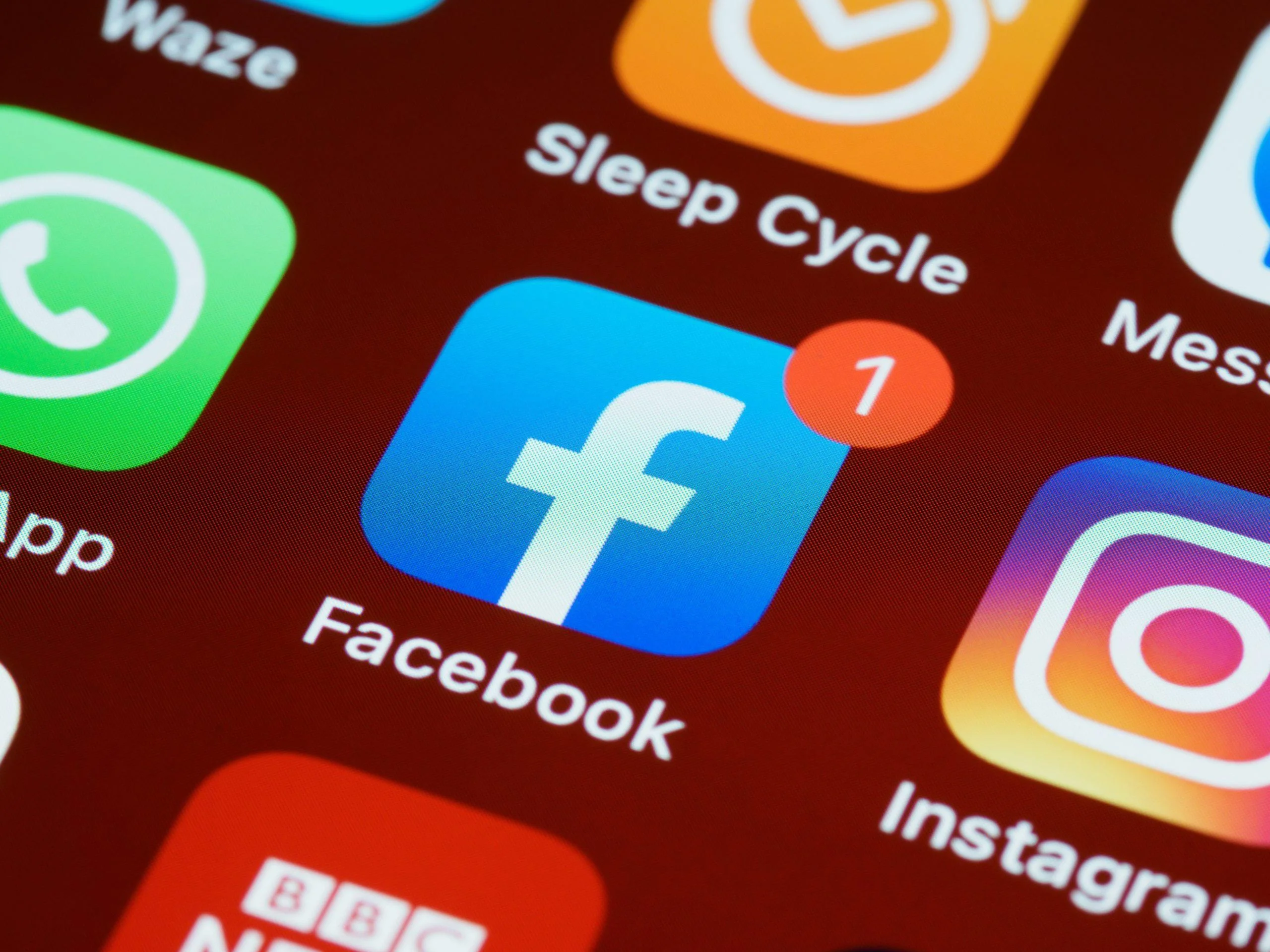 Smartphone home screen showing the Facebook app icon with a notification badge, relevant to iOS 14 privacy changes affecting Facebook ad tracking.