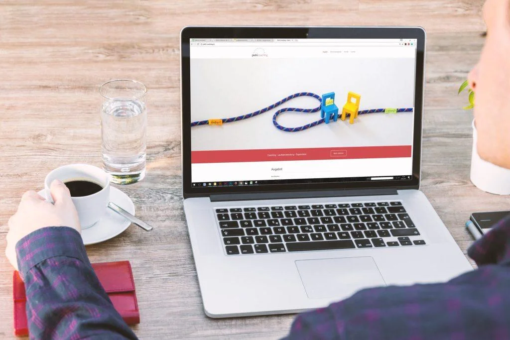 Person viewing a coaching website on a laptop, illustrating how consent mode affects user browsing experience.