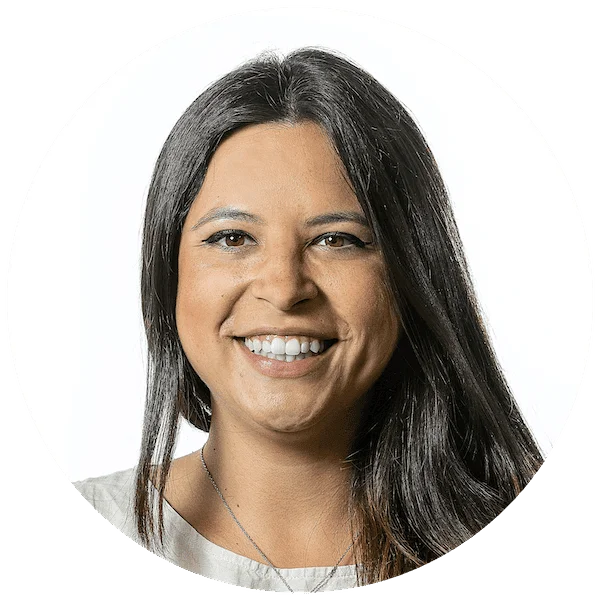 Profile photo of a smiling woman with long dark hair, wearing a light-colored top and necklace.
